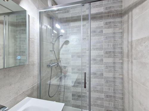 une salle de bain avec une douche en verre avec un lavabo dans l'établissement Studio lumineux 5 pers, 50m des pistes avec balcons ensoleillés - FR-1-416-225, à La Toussuire