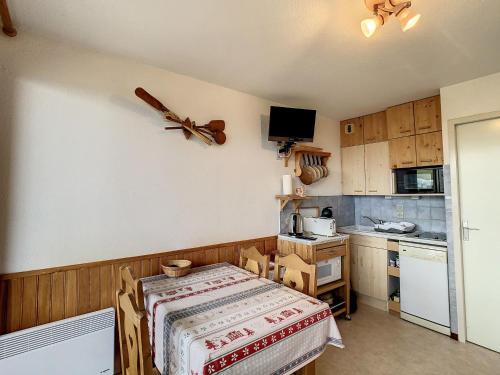 une petite cuisine avec une table dans une pièce dans l'établissement Appartement cosy pour 4 à La Toussuire, proche pistes et commerces - FR-1-416-227, à La Toussuire