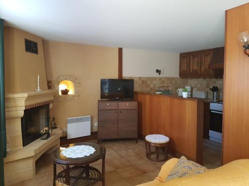 un salon avec une cuisine et une cheminée dans l'établissement Maison conviviale à Proissans avec jardin et jeux de plein air - FR-1-616-440, à Proissans