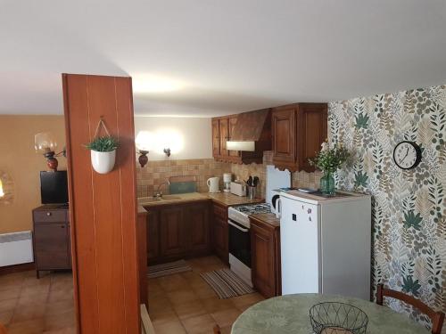 une cuisine avec des armoires en bois et un réfrigérateur blanc dans l'établissement Maison conviviale à Proissans avec jardin et jeux de plein air - FR-1-616-440, à Proissans