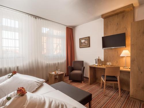 a hotel room with a bed and a desk at Gasthaus zur Krone in Weingarten (Karlsruhe)