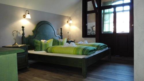 a bedroom with a bed with green and yellow sheets at Hotel Villa Alice in Thale
