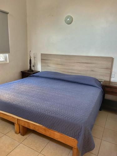 a bedroom with a large bed with a blue comforter at Apartment 3 Maleconcito del Sol Barra de Navidad in Barra de Navidad