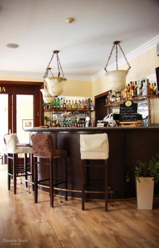 a bar with chairs and a counter with drinks at Pensjonat Lorien in Szczawno-Zdrój