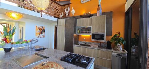 a kitchen with a sink and a stove top oven at Villa Ta'u Here in Arue