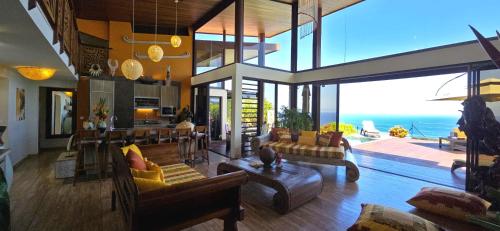 a living room with furniture and a view of the ocean at Villa Ta'u Here in Arue