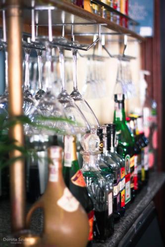 a group of bottles and glasses on a bar at Pensjonat Lorien in Szczawno-Zdrój