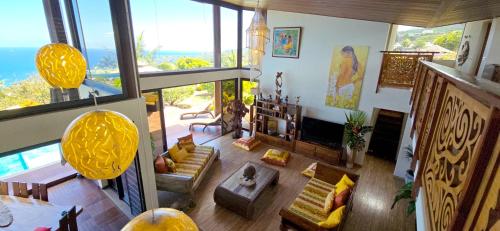 a living room with a lot of windows at Villa Ta'u Here in Arue