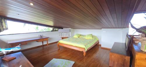 a bedroom with a bed and a desk in a room at Villa Ta'u Here in Arue