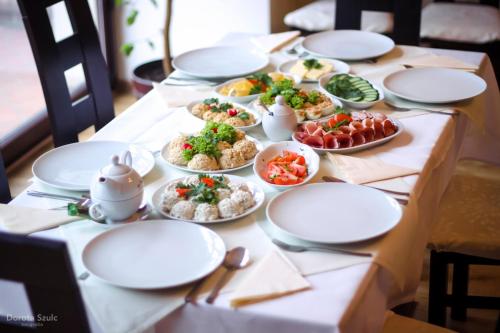a table with plates of food on it at Pensjonat Lorien in Szczawno-Zdrój