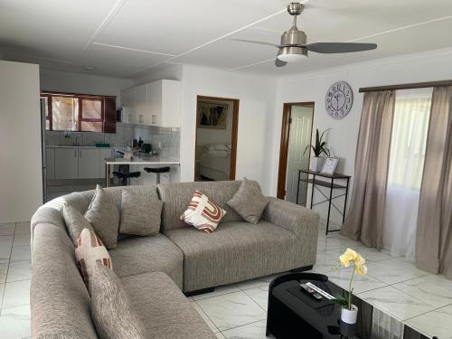 a living room with a couch and a table at Luxury 1 Bdr Garden Cottage in Windhoek