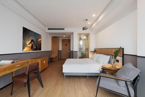 a hotel room with a bed and a desk and chair at Mcsrh Hotel-Chongqing Guanyinqiao in Chongqing