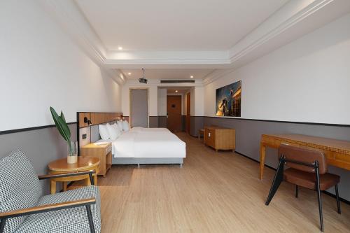 a hotel room with a bed and a piano at Mcsrh Hotel-Chongqing Guanyinqiao in Chongqing
