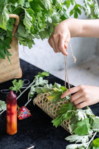 a person holding a potted plant on a table at Yakamoz Qianchuan Hotel in Lin'an