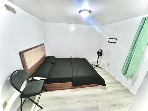 1 dormitorio con 1 cama negra y 1 silla en Da-7 Room Near Airport, en Brampton