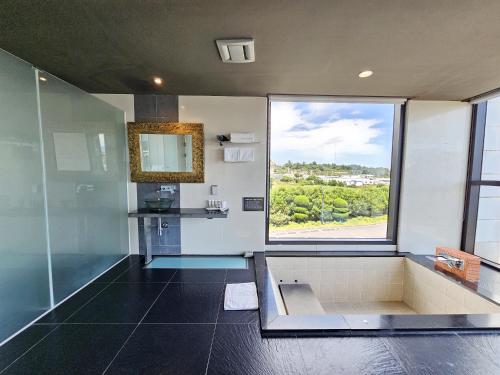a bathroom with a shower and a large window at Hotel Scarboro Jeju in Seogwipo