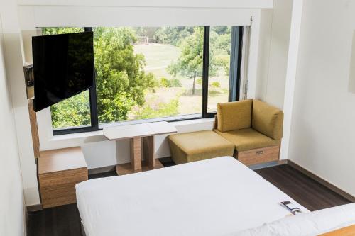 a bedroom with a bed and a chair and a window at Crowne Plaza Canberra by IHG in Canberra