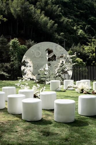 a group of white benches sitting in the grass at Yakamoz Qianchuan Hotel in Lin'an