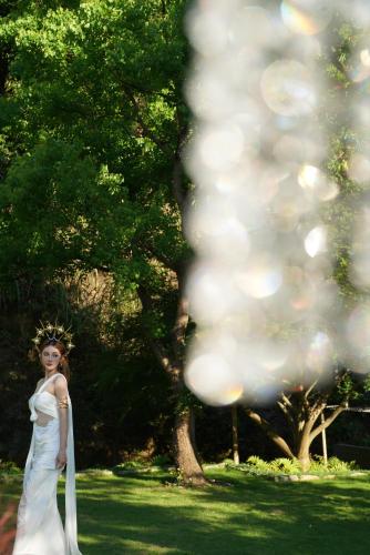 a woman in a wedding dress standing in the grass at Yakamoz Qianchuan Hotel in Lin'an