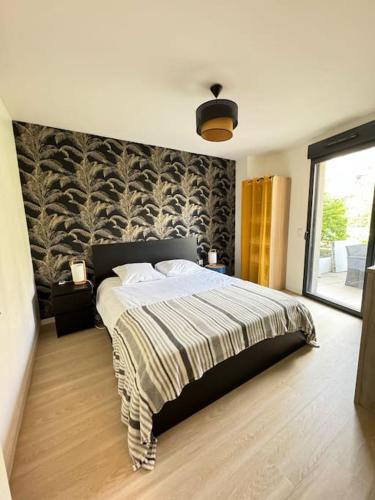 - une chambre avec un grand lit escamotable dans l'établissement Appartement spacieux avec terrasse, à Caen