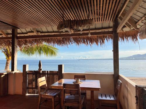 a table and chairs on a patio with a view of the ocean at The Shack Private Beach House in Santander