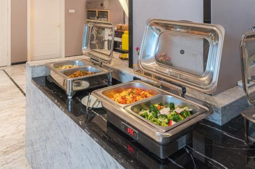 a buffet with two trays of food on a counter at Quanzhou Fengze Square West Street Wanxin Zhige Hotel in Quanzhou