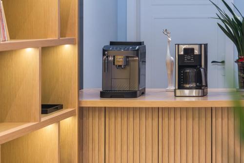 a coffeemaker sitting on a shelf with a coffee maker at Quanzhou Fengze Square West Street Wanxin Zhige Hotel in Quanzhou