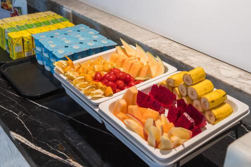 two trays of different types of fruit on a counter at Quanzhou Fengze Square West Street Wanxin Zhige Hotel in Quanzhou