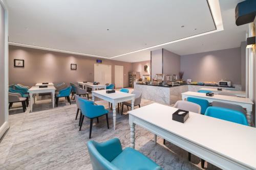 a restaurant with tables and chairs and a kitchen at Quanzhou Fengze Square West Street Wanxin Zhige Hotel in Quanzhou