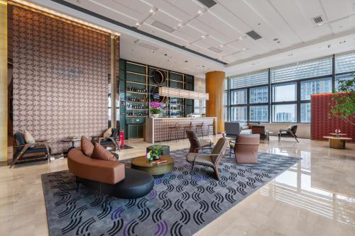 a lobby with couches and chairs in a building at 佛山南海金融城瑾程酒店 in Nanhai