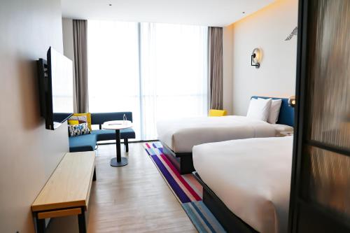 a hotel room with two beds and a tv at Aloft Beijing Huairou in Huairou