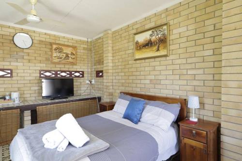 a bedroom with a bed with blue and white pillows at Family Retreat in Central Tenterfield in Tenterfield
