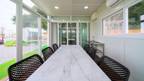 a dining room with a large marble table and chairs at Hwaseong Refreshing Glamping&Caravan in Hwaseong