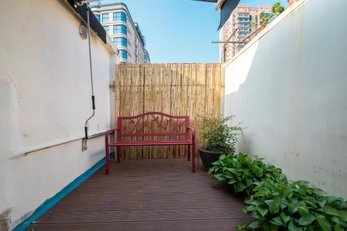 a red bench sitting on a walkway next to a fence at Tonight Homestay South Shanxi Road Shanghai in Shanghai