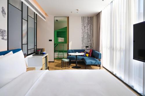 a bedroom with a bed and a living room at Aloft Beijing Huairou in Huairou