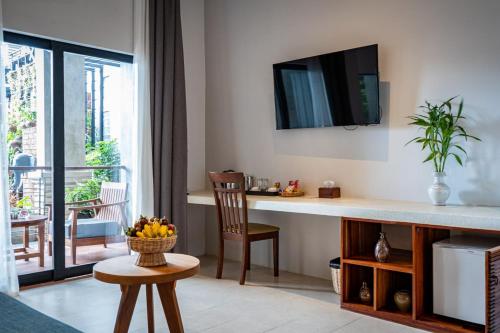 a living room with a desk with a television on the wall at Grange in Siem Reap