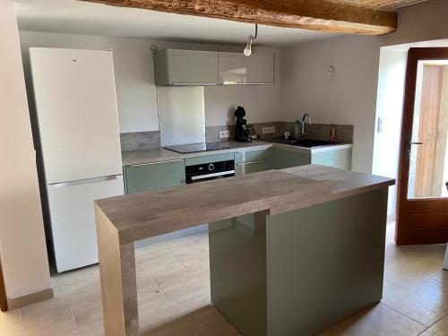 une cuisine avec un grand îlot au milieu dans l'établissement Maison en pierres rénovée MONS 83, à Mons