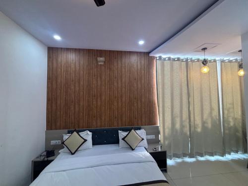 a bedroom with a bed and a large window at Hotel Hanuman Palace-450 meter Khatu Shayam Ji Temple in Khātu