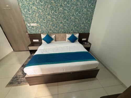 a small bed with blue pillows in a room at Hotel Hanuman Palace-450 meter Khatu Shayam Ji Temple in Khātu