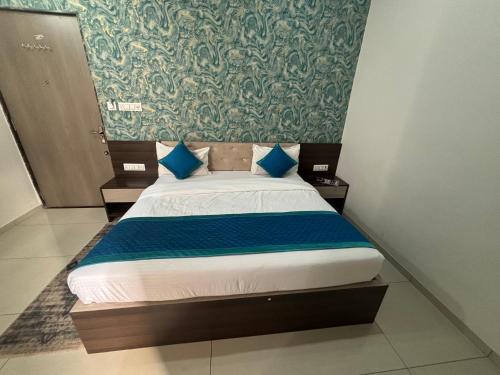 a bed with blue pillows in a room at Hotel Hanuman Palace-450 meter Khatu Shayam Ji Temple in Khātu