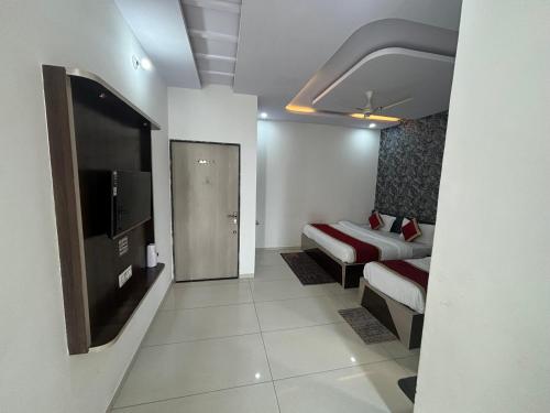 a hotel room with two beds and a television at Hotel Hanuman Palace-450 meter Khatu Shayam Ji Temple in Khātu