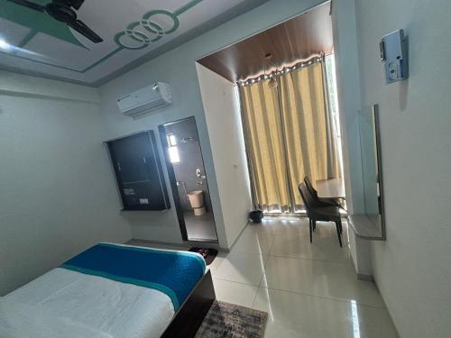 a hotel room with a bed and a desk and a window at Hotel Hanuman Palace-450 meter Khatu Shayam Ji Temple in Khātu