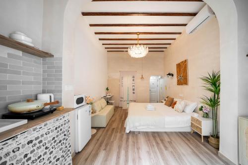 a bedroom with a white bed and a kitchen at Tonight Homestay South Shanxi Road Shanghai in Shanghai