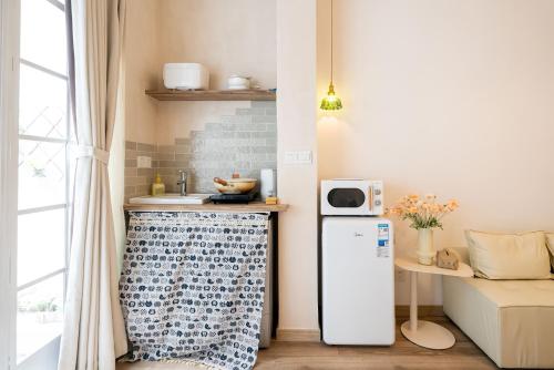 a small kitchen with a refrigerator and a microwave at Tonight Homestay South Shanxi Road Shanghai in Shanghai