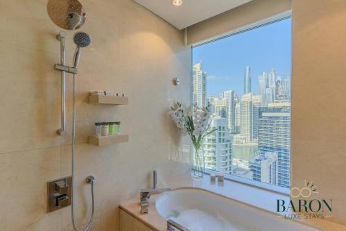 ein Badezimmer mit Badewanne und Fenster in der Unterkunft The Modern in Dubai