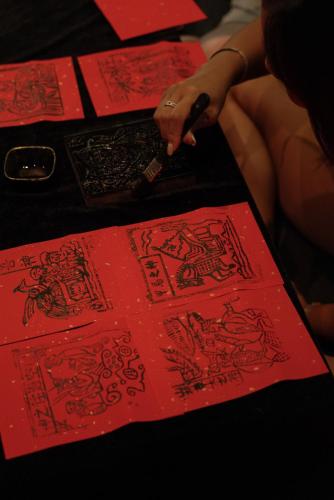 a person drawing on red cards on a table at Yakamoz Qianchuan Hotel in Lin'an