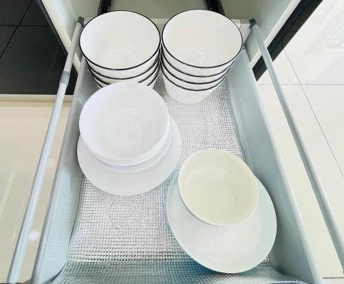 a group of white plates on a shelf in a refrigerator at ELYSIA-Near Gleaneagles & Legoland-2RB WarmQ Suite Max7pax-WaterDispenser in Nusajaya