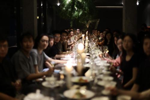 a group of people sitting at a long table at Yakamoz Qianchuan Hotel in Lin'an