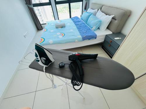 a room with a surfboard on the floor next to a bed at ELYSIA-Near Gleaneagles & Legoland-2RB WarmQ Suite Max7pax-WaterDispenser in Nusajaya