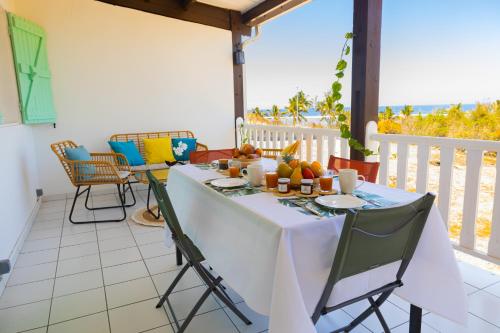a table with a white table cloth on a balcony at Le chant du Lagon in La Saline les Bains